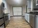 Eat-in kitchen with stainless steel appliances, stone backsplash and wood-look flooring at 393 Macland Dr, Lawrenceville, GA 30045