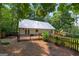 View of the backyard deck of a home, fenced in yard and lush surrounding greenery at 3515 Chattahoochee Rd, Cumming, GA 30041