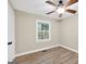 Bright bedroom with wood-look flooring, a ceiling fan, and a window with tree views at 3515 Chattahoochee Rd, Cumming, GA 30041