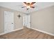 Bedroom with wood flooring, ceiling fan, and doors leading to closets and hallways at 3515 Chattahoochee Rd, Cumming, GA 30041