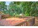 Large wood deck overlooking the back yard has metal railing and ample space for entertaining at 3515 Chattahoochee Rd, Cumming, GA 30041