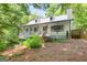 Quaint home with a front porch and a manicured lawn, set against a backdrop of lush trees at 3515 Chattahoochee Rd, Cumming, GA 30041