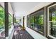 Spacious porch with dark wood floors, offering serene views of the surrounding greenery at 3515 Chattahoochee Rd, Cumming, GA 30041