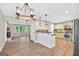 Open-concept kitchen with updated appliances, modern cabinetry, and adjacent dining area with fireplace at 3515 Chattahoochee Rd, Cumming, GA 30041