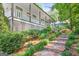 Landscaped front garden leading to a charming home with a welcoming porch and stone steps at 3515 Chattahoochee Rd, Cumming, GA 30041