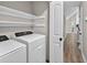 Laundry area features new appliances, white shelving, and easy access to the living room at 3515 Chattahoochee Rd, Cumming, GA 30041