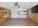 Cottage living area with wood-look flooring, wood accents, and a modern ceiling fan at 3515 Chattahoochee Rd, Cumming, GA 30041