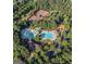 Aerial view of community featuring swimming pools, splash pad, playground, and tennis courts all surrounded by lush trees at 6142 Golf View Xing, Locust Grove, GA 30248
