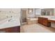 Well-lit bathroom featuring a tub, separate shower, dual sinks, and tile flooring at 6142 Golf View Xing, Locust Grove, GA 30248