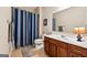 Bathroom with a wood vanity, tiled floor, a white countertop sink, and a framed mirror at 6142 Golf View Xing, Locust Grove, GA 30248