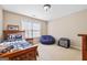 Neutral bedroom featuring a wood frame bed, a blue beanbag, and carpet flooring at 6142 Golf View Xing, Locust Grove, GA 30248