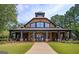 Stunning clubhouse with large porch, beautiful columns, and manicured landscaping creating a welcoming and luxurious community gathering space at 6142 Golf View Xing, Locust Grove, GA 30248