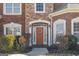 Close-up of home's inviting front door with wreath, framed by elegant sidelights and manicured bushes at 6142 Golf View Xing, Locust Grove, GA 30248