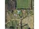 Aerial view showcasing the property's layout, including the main house, outbuildings, and surrounding land at 310 Trestle Rd, Locust Grove, GA 30248