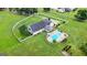 Aerial view of a well-maintained property with a pool, large yard, and white fence at 310 Trestle Rd, Locust Grove, GA 30248