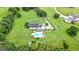 Stunning aerial view of the property featuring a pool, white fence, and lush green landscaping at 310 Trestle Rd, Locust Grove, GA 30248