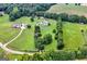 Wide aerial shot with lush landscaping, driveway, a main house, and a guest house at 310 Trestle Rd, Locust Grove, GA 30248