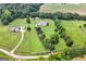 Sprawling estate aerial showcasing the main house, a guest house, and tree-lined driveway at 310 Trestle Rd, Locust Grove, GA 30248