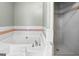 Bathroom featuring a white tub, and walk-in shower at 310 Trestle Rd, Locust Grove, GA 30248