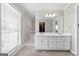 Bathroom with double sinks, bright lighting, and a large walk-in closet at 310 Trestle Rd, Locust Grove, GA 30248