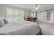 Bright bedroom featuring a ceiling fan, sliding barn door, and desk area with large windows at 310 Trestle Rd, Locust Grove, GA 30248