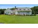 Beautiful home with a classic white porch and manicured lawn in a serene, suburban setting at 310 Trestle Rd, Locust Grove, GA 30248