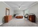 Spacious main bedroom with a king-sized bed, dresser, rocking chair, and ample natural light at 310 Trestle Rd, Locust Grove, GA 30248