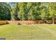 A backyard with a fire pit surrounded by mature trees, perfect for outdoor gatherings at 27 Riverview, Euharlee, GA 30145