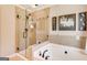 Bright bathroom featuring a glass enclosed shower and soaking tub with black fixtures and neutral tiling at 27 Riverview, Euharlee, GA 30145