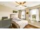 Comfortable bedroom with a queen-sized bed, ceiling fan, and two windows with natural light and a chair at 27 Riverview, Euharlee, GA 30145
