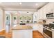 Bright kitchen featuring granite countertops, a center island, stainless steel appliances, and hardwood floors at 27 Riverview, Euharlee, GA 30145