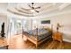 This main bedroom features a wooden bed frame, tray ceiling, and hardwood floors at 27 Riverview, Euharlee, GA 30145