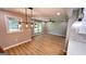 Dining area with modern pendant lighting, open to the living room and kitchen with hardwood floors at 5324 Joan Of Arc, Atlanta, GA 30349