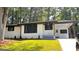 Charming, remodeled home featuring white painted brick, black trim, and a well-manicured front lawn at 5324 Joan Of Arc, Atlanta, GA 30349
