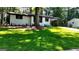 Well-manicured lawn with mature shade tree and charming house with dark trim at 5324 Joan Of Arc, Atlanta, GA 30349