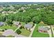 Aerial view of three homes and verdant neighborhood featuring lush green trees at 230 Hummingbird Ct, Hampton, GA 30228