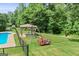 A backyard featuring a fenced pool, gazebo, swing set and ample lawn space for outdoor activities at 230 Hummingbird Ct, Hampton, GA 30228