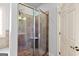 A glass-enclosed shower with tiled walls, a corner seat, and a showerhead is visible at 230 Hummingbird Ct, Hampton, GA 30228