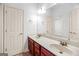 Bright bathroom features a double sink vanity with cherry wood cabinets and a large mirror at 230 Hummingbird Ct, Hampton, GA 30228