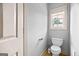 Bathroom featuring a toilet, a window, and neutral walls at 230 Hummingbird Ct, Hampton, GA 30228