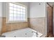 A soaking tub with tiled walls and a window is positioned next to a glass shower at 230 Hummingbird Ct, Hampton, GA 30228