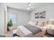 Staged bedroom with a plush bed, artwork, and a leafy potted plant at 230 Hummingbird Ct, Hampton, GA 30228