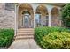 Covered front porch has brick steps and seating area at 230 Hummingbird Ct, Hampton, GA 30228