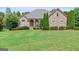 Beautiful brick home featuring a well-manicured lawn and mature landscaping, enhancing its curb appeal at 230 Hummingbird Ct, Hampton, GA 30228