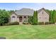 Charming brick home with well-manicured lawn, mature trees and manicured shrubbery at 230 Hummingbird Ct, Hampton, GA 30228