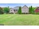 Brick home features manicured lawn, mature trees, and well-maintained landscaping at 230 Hummingbird Ct, Hampton, GA 30228