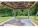 A concrete slab with a gazebo on a grassy lot, surrounded by mature trees at 230 Hummingbird Ct, Hampton, GA 30228
