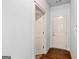 Hallway with neutral walls, wood flooring, and interior doors at 230 Hummingbird Ct, Hampton, GA 30228