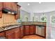 Kitchen with wooden cabinets, stainless steel dishwasher and a view to the breakfast area at 230 Hummingbird Ct, Hampton, GA 30228