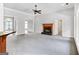 Bright living room featuring a ceiling fan, fireplace, and ample natural light at 230 Hummingbird Ct, Hampton, GA 30228